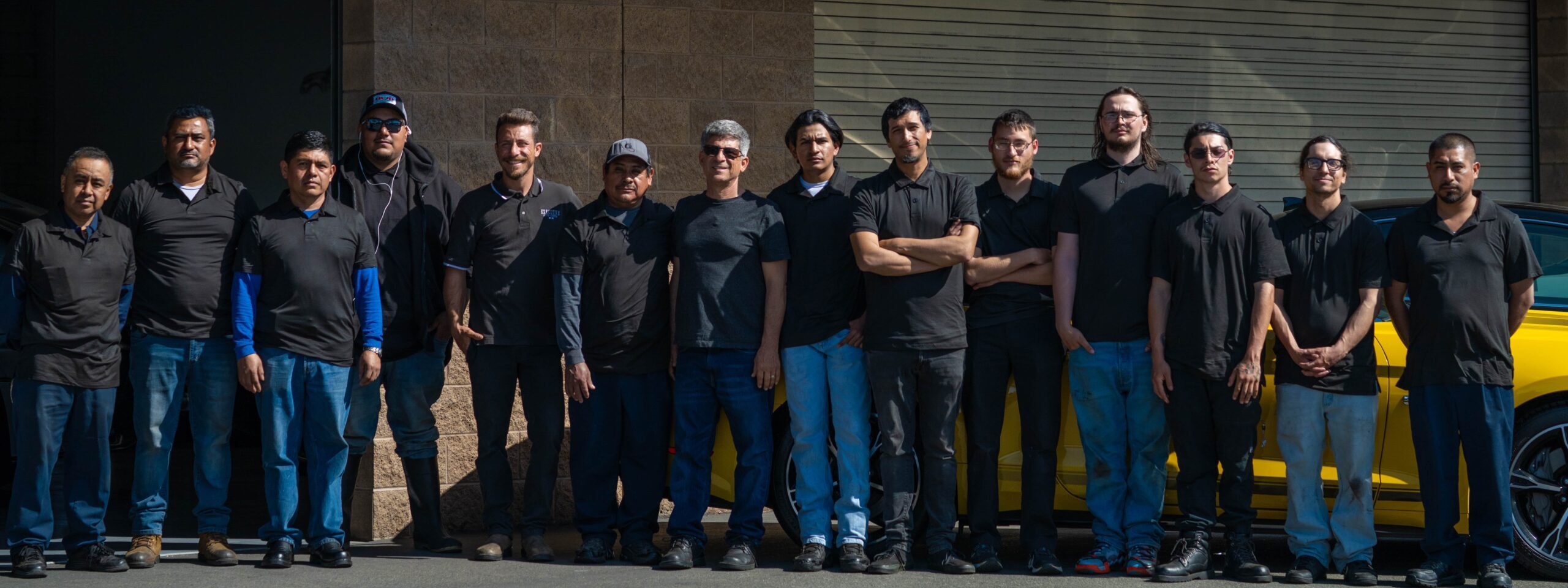 The team of Executive Auto Detailing standing proudly in front of the building.